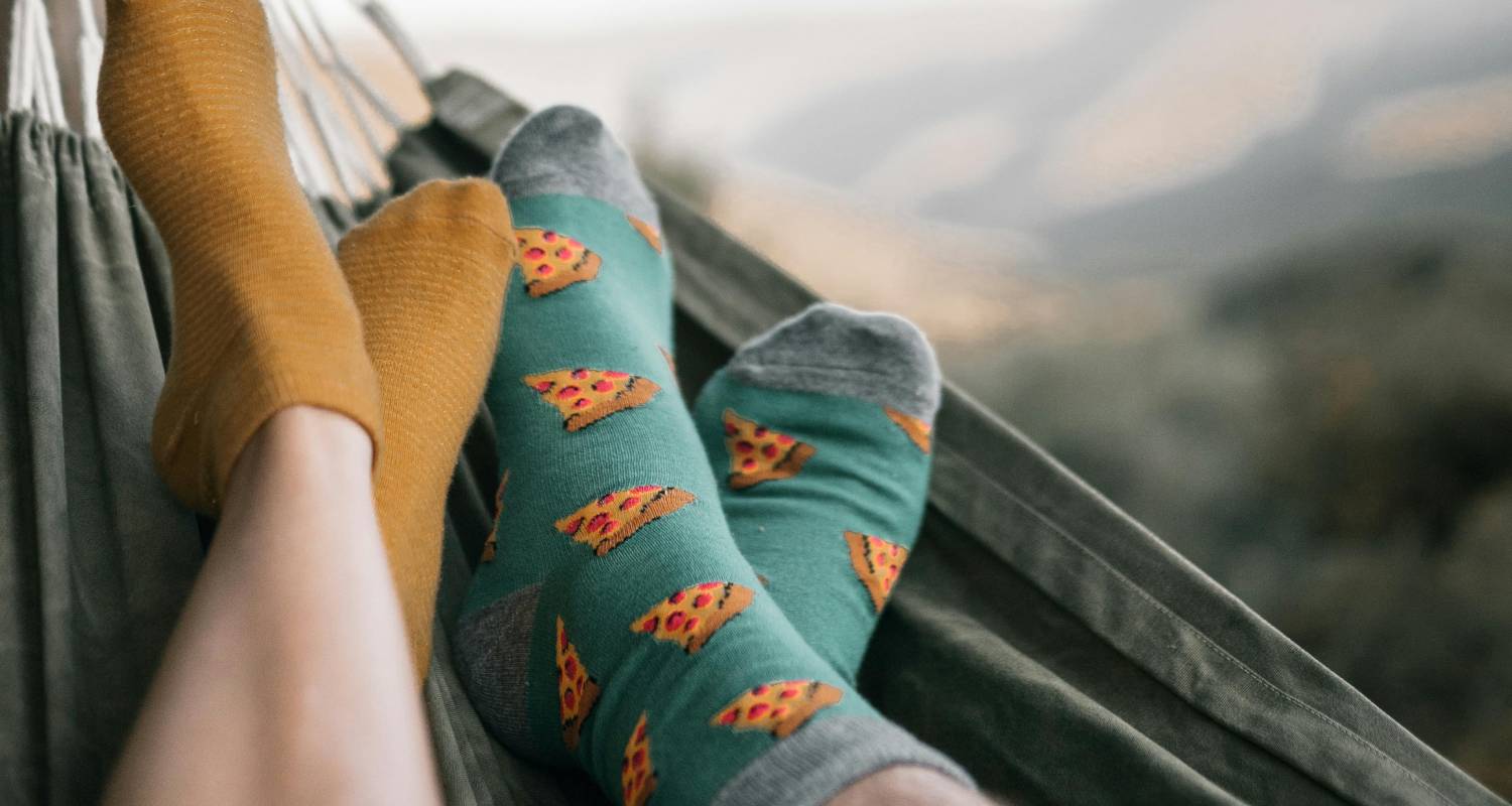 Two people relaxing in a hammock wearing colorful socks